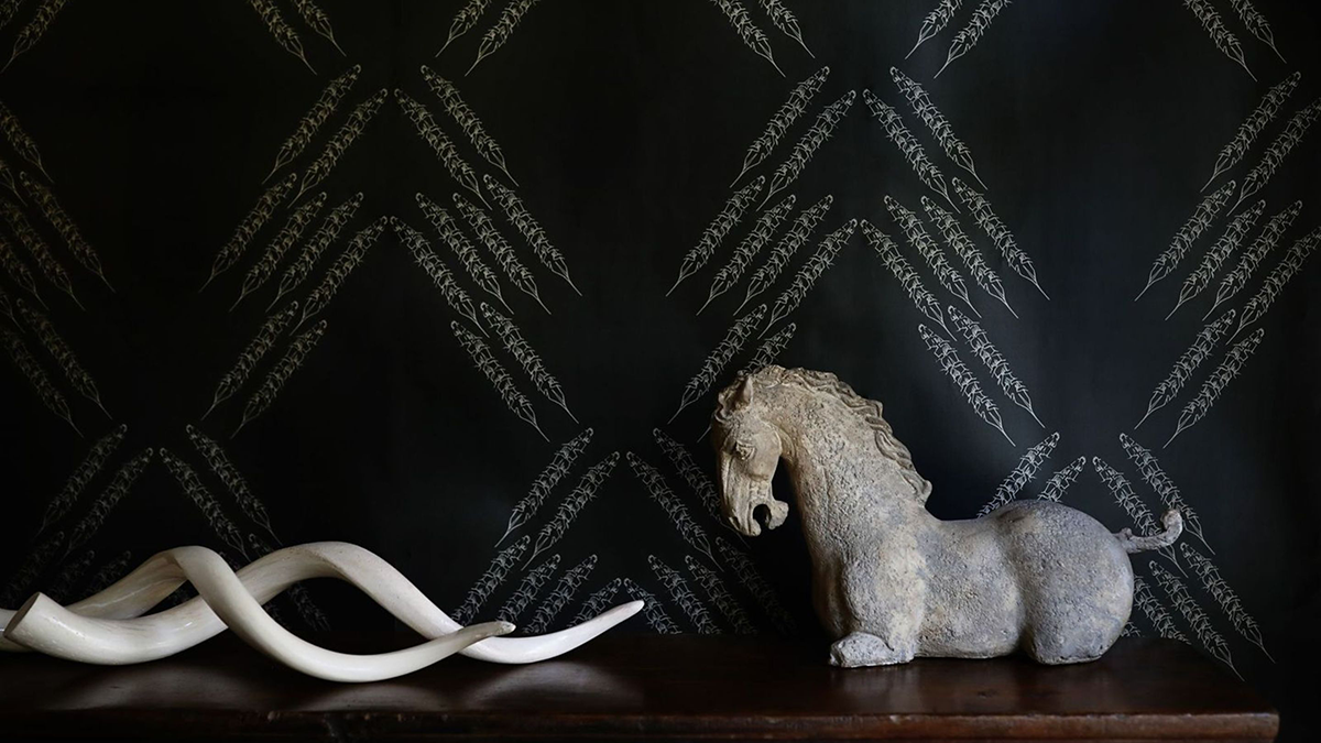 Decorative horse sculpture on a dark surface with a patterned black background